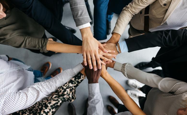 People holding hands top of each other