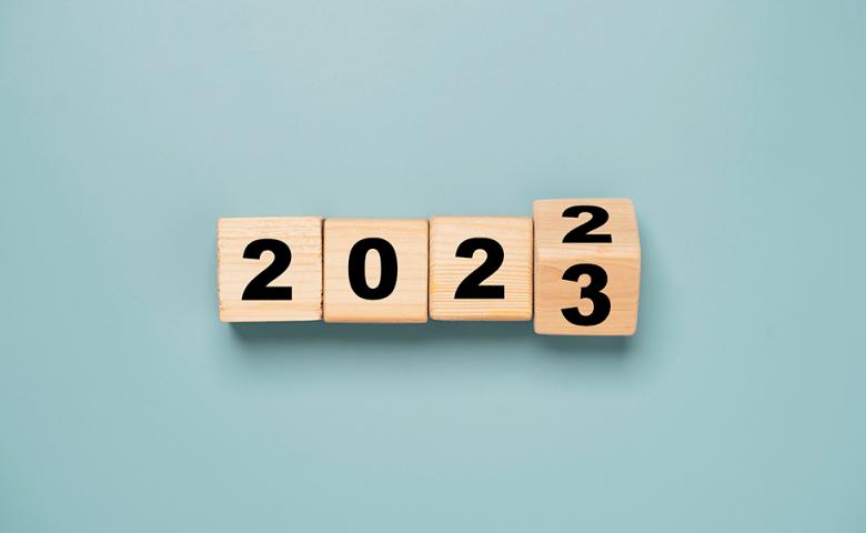 Wooden blocks with numbers on them that show it changing from 2022 to 2023, all on a light blue background.