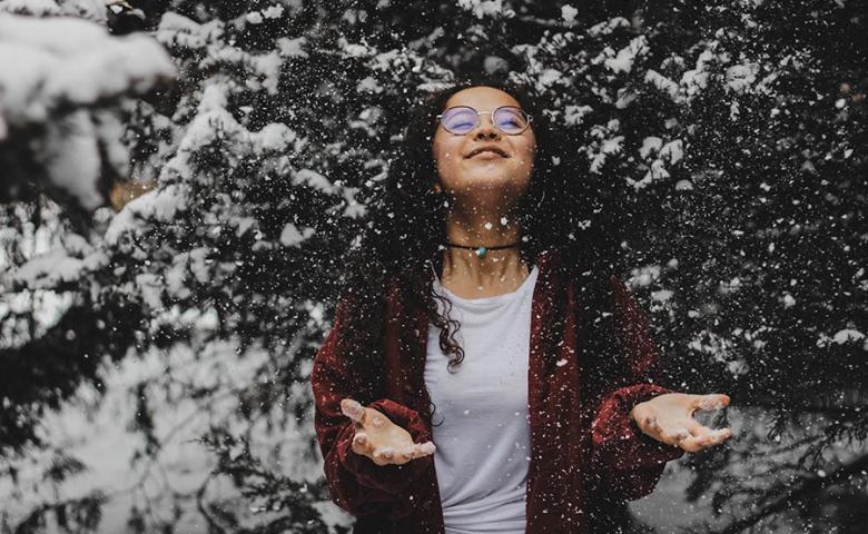 Woman outside enjoying the falling snow