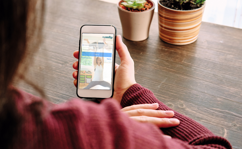 Close up of woman holding a smartphone with the My ASEBP mobile app on the screen
