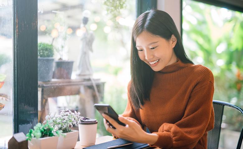 Young woman using her phone in a cafe