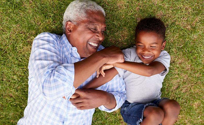 Grandfather and grandson playing on the grass